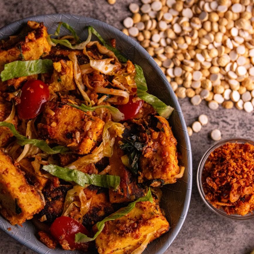 a bowl of cooked food in a bowl on a rustic background